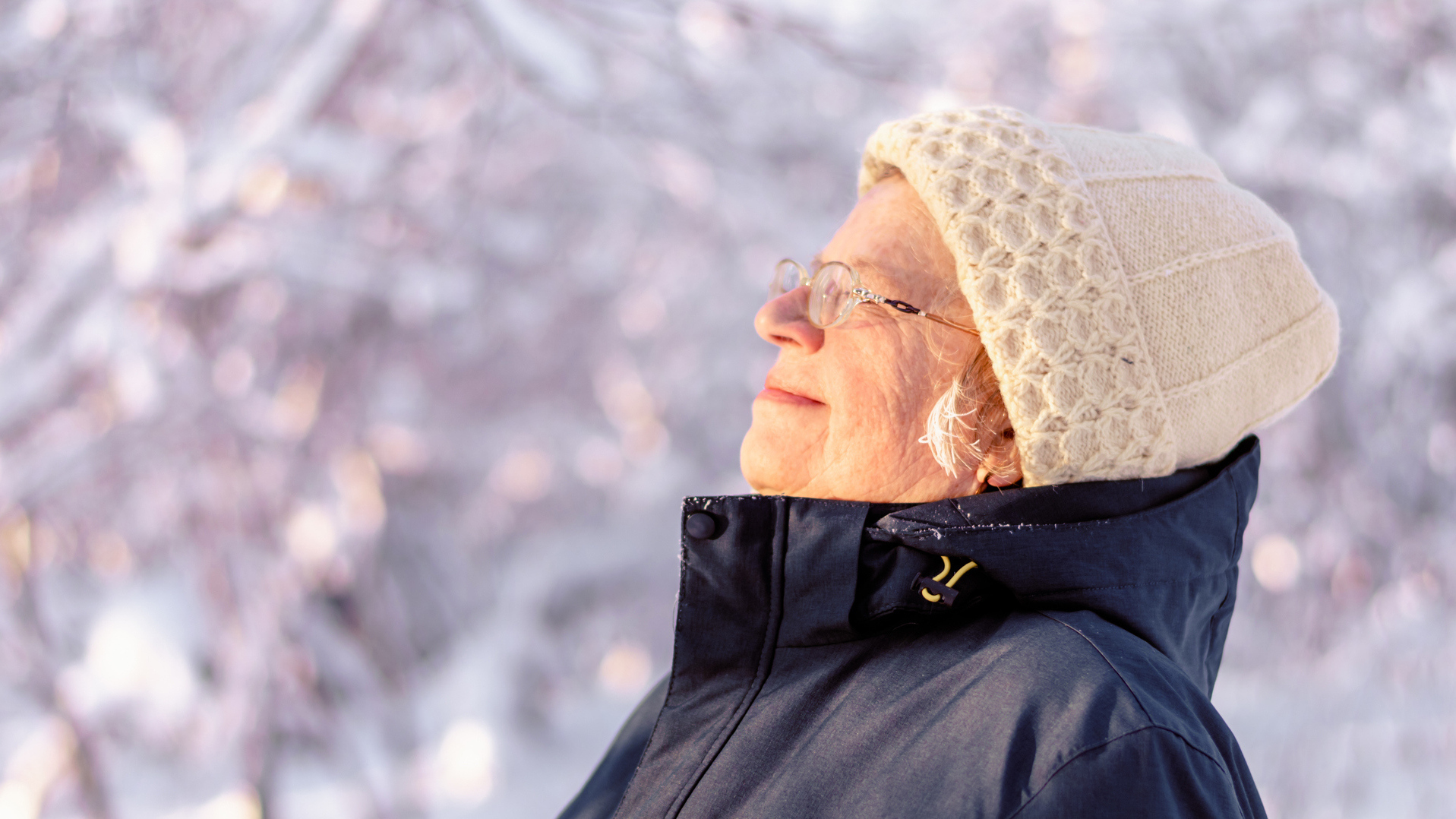 Eldre kvinne ser mpt lyset i vintervær.