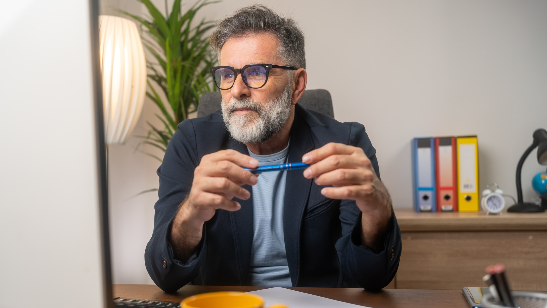 Mann ser på PC på et hjemmekontor